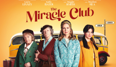 The Miracle Club image of 4 women in front of a yellow bus