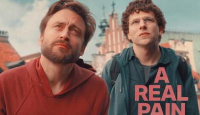 A real pain film poster showing 2 men played by kieran culkin and jessie eisenberg looking up at something in the distance