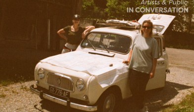 2 women stand beside an old renault car preparing for a road trip