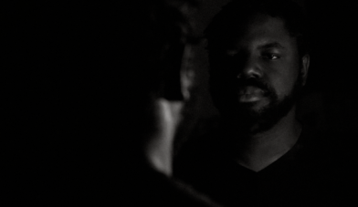 Dagogo Hart a man looking in mirror in dark room