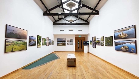 Photo of our gallery space featuring an exhibition of aerial photography