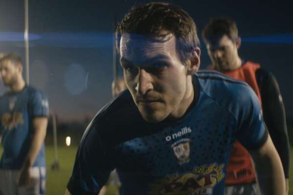 Man in a GAA jersey close up in action