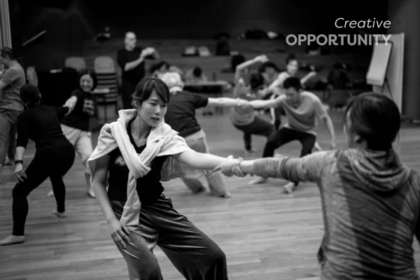 Room of people doing a physical activity y holding each other by the arms and title creative opportunity