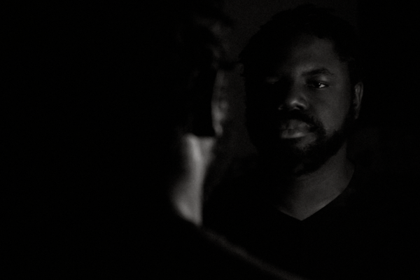 Dagogo Hart a man looking in mirror in dark room